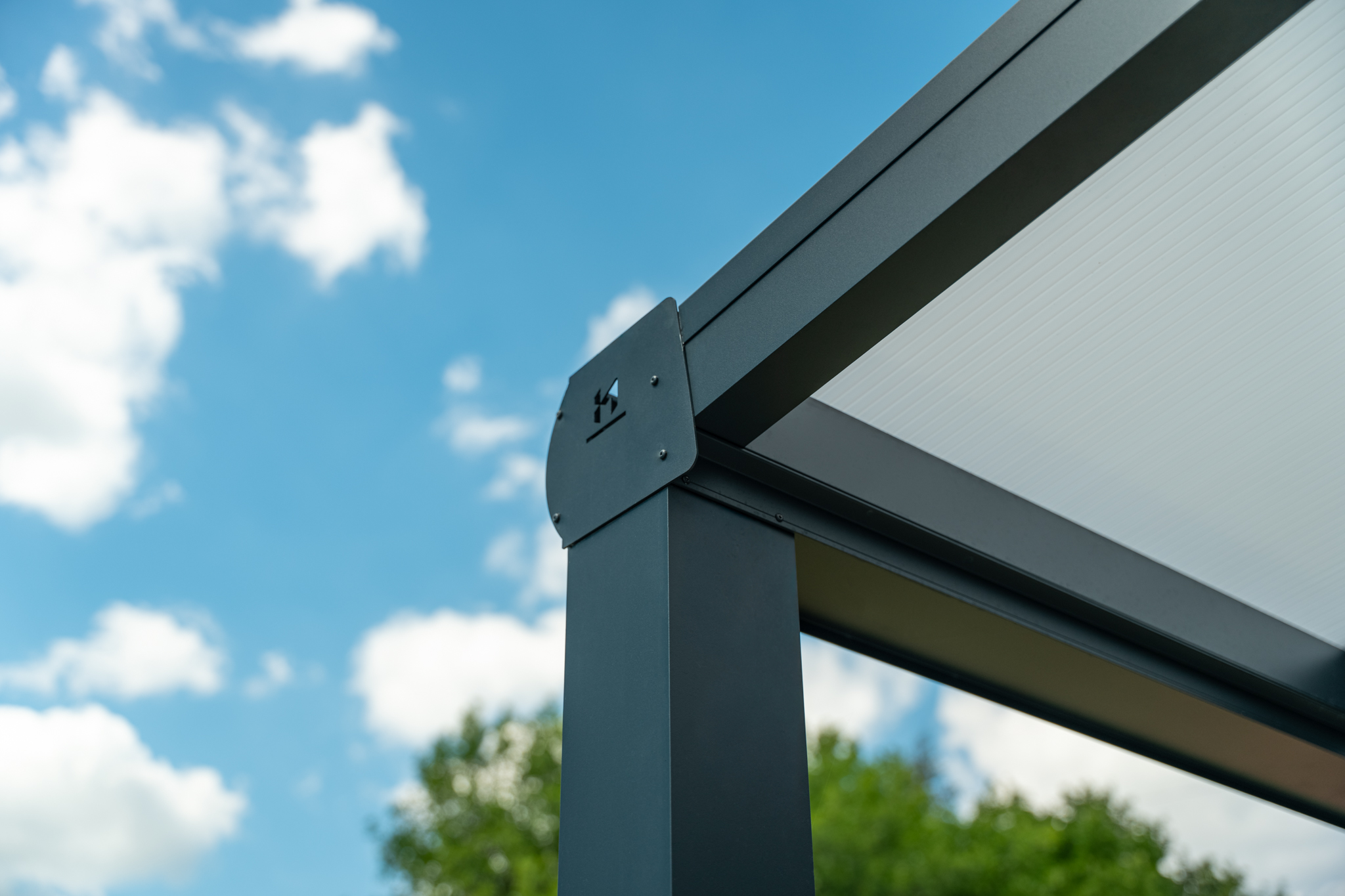 Harmony — pergola nad tarasem domu jednorodzinnego — detal konstrukcji z logo